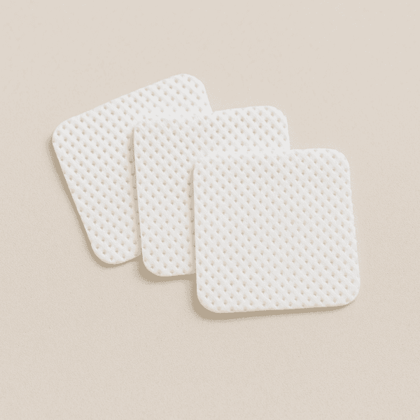 Mini toallitas blancas sin pelusa apiladas, ideales para manicura y tratamientos de uñas.