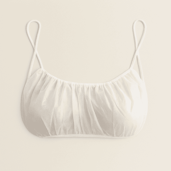 Sujetador desechable blanco, fabricado en polipropileno antialérgico, diseñado para un solo uso en centros de estética, spas y clínicas.