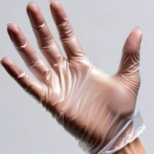 Mano con guante de vinilo transparente talla L sin polvo, mostrando ajuste cómodo y superficie lisa sobre fondo neutro.