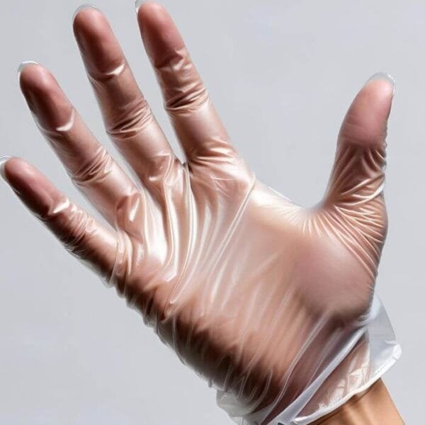 Mano con guante de vinilo transparente talla L sin polvo, mostrando ajuste cómodo y superficie lisa sobre fondo neutro.