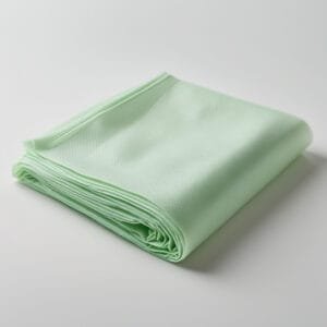 Sábana desechable de color verde claro, doblada y fabricada con material no tejido, utilizada en spas, salones de belleza y centros de estética.