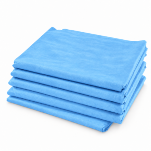 Pack de 5 sábanas cubrecamillas azules de 80 x 210 cm, dobladas y apiladas sobre fondo blanco
