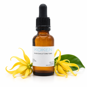 Frasco KOKEN de aceite esencial de ylang ylang con flores amarillas sobre fondo blanco